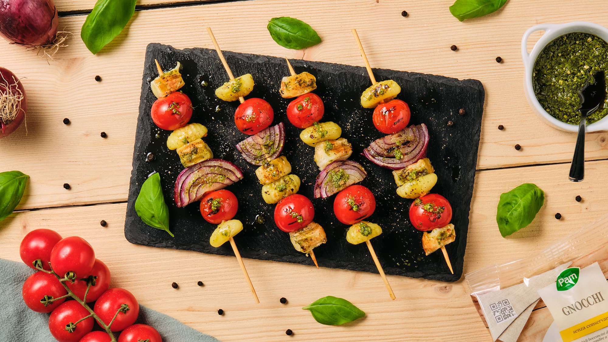 Spiedini alla griglia di gnocchi, pomodorini, cipolla rossa, scamorza affumicata e pesto