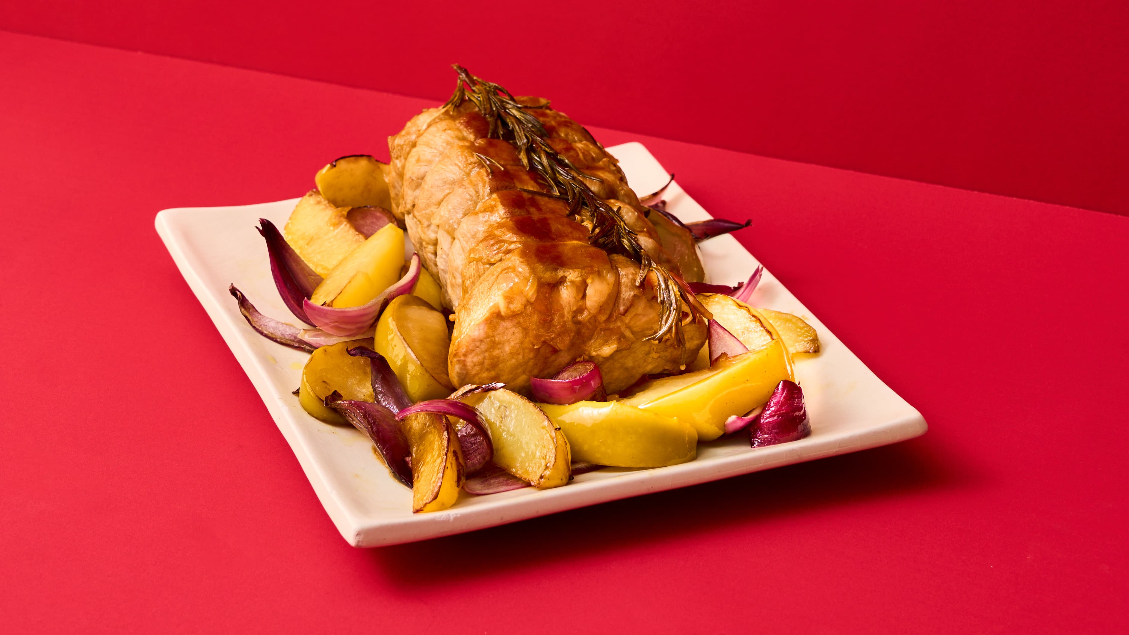 Arista di maiale con pancetta e rosmarino con contorno di patate, mele e cipolle arrosto