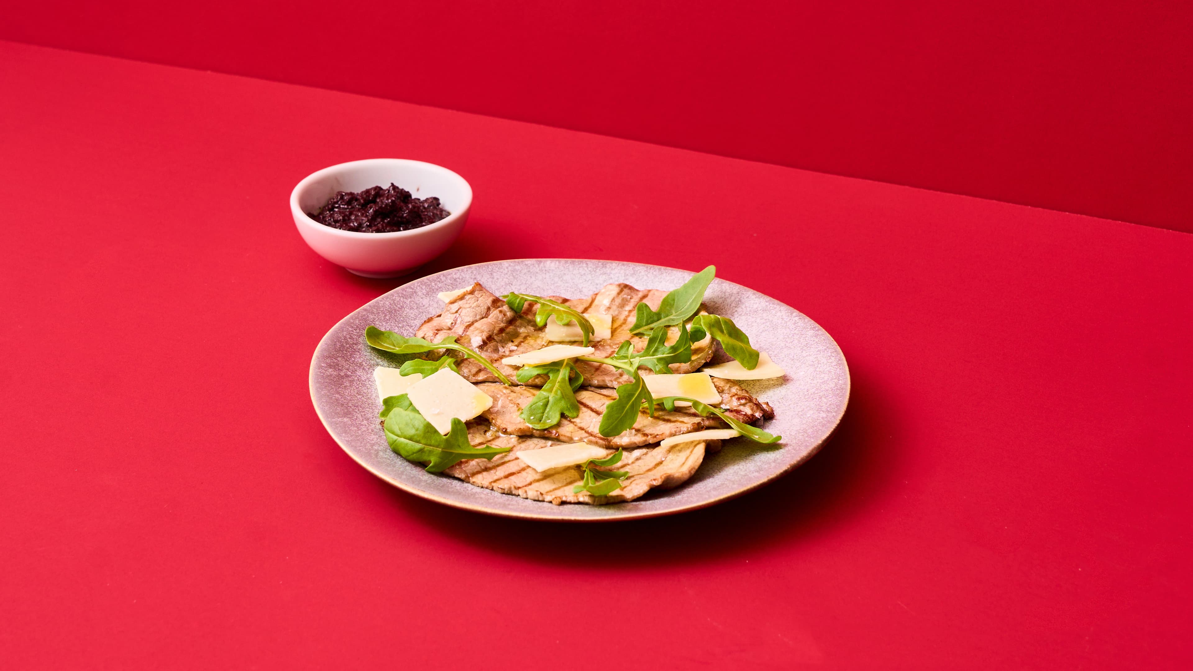 Fettine sottili con rucola, grana, sale maldon e patè di olive