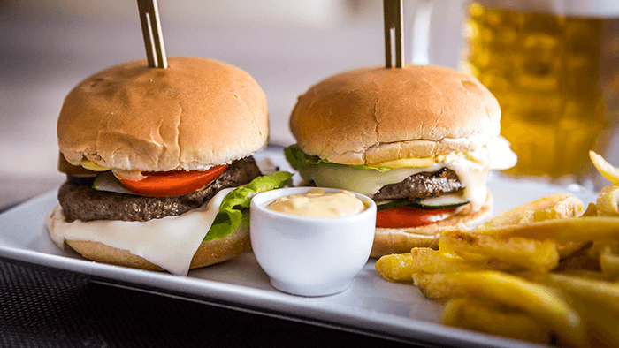 Hamburger con pomodoro, cetriolo e cipolla rossa e patate fritte